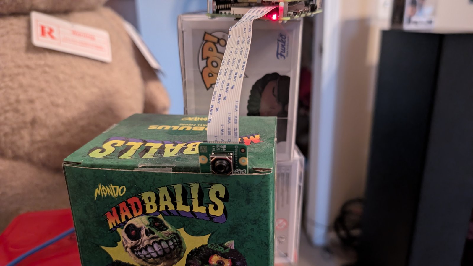 Camera Module 3 resting on a cardboard collectible box before the printed mount