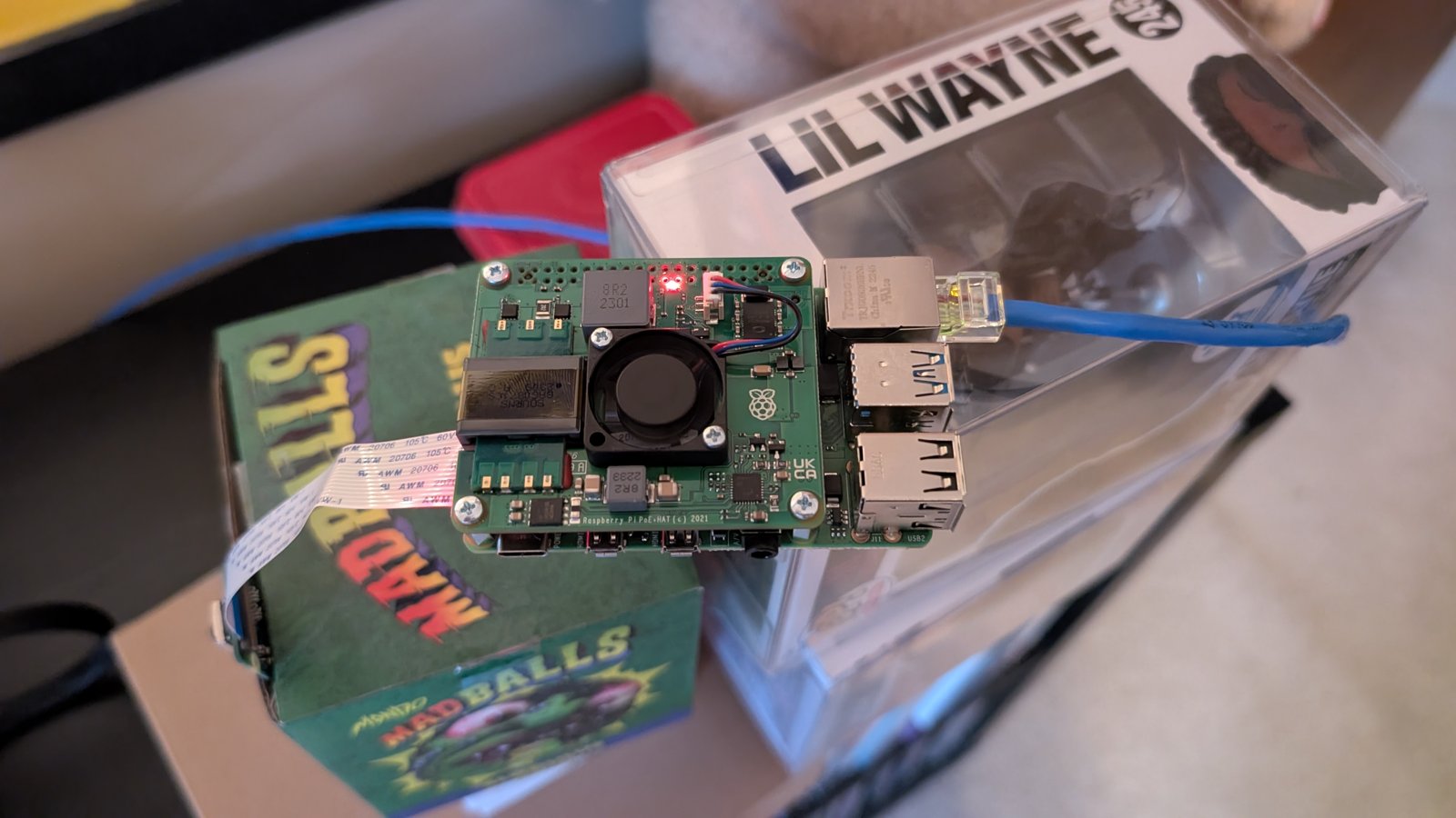 Raspberry Pi 4 with PoE+ HAT, cooling fan, Ethernet cable, and camera ribbon cable