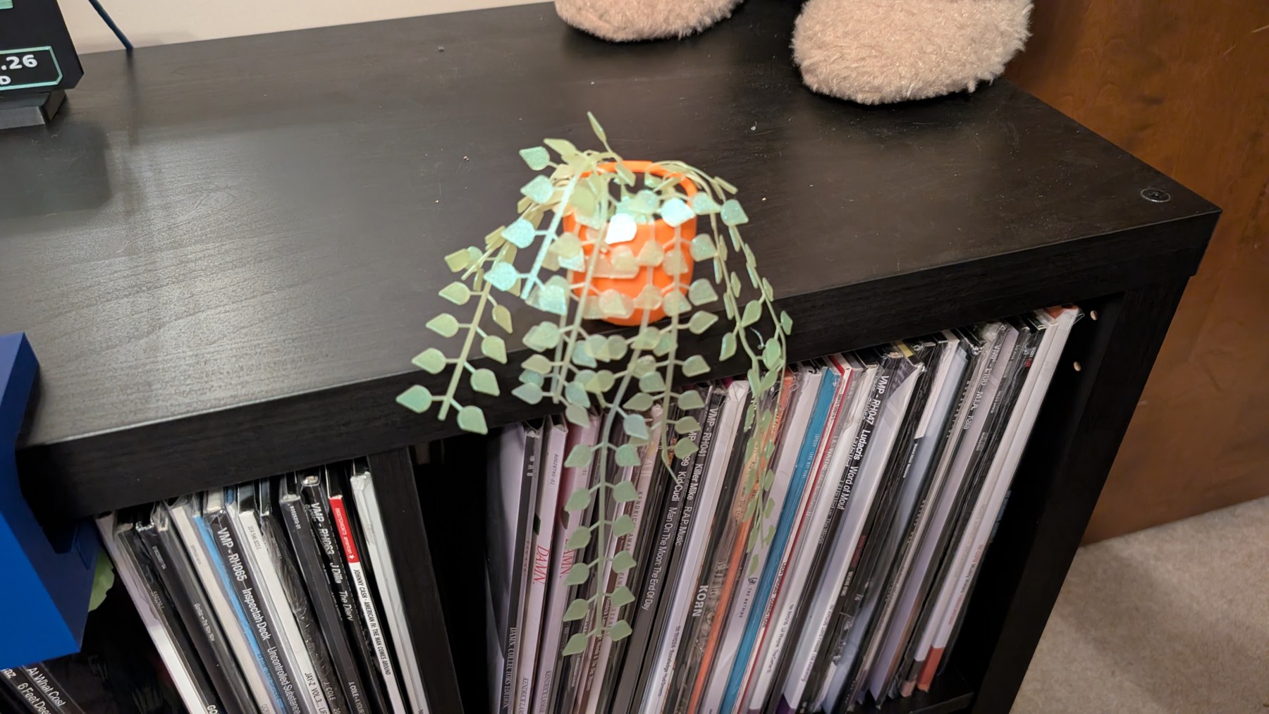 Assembled printed plant with trailing leaves in an orange pot on the shelf