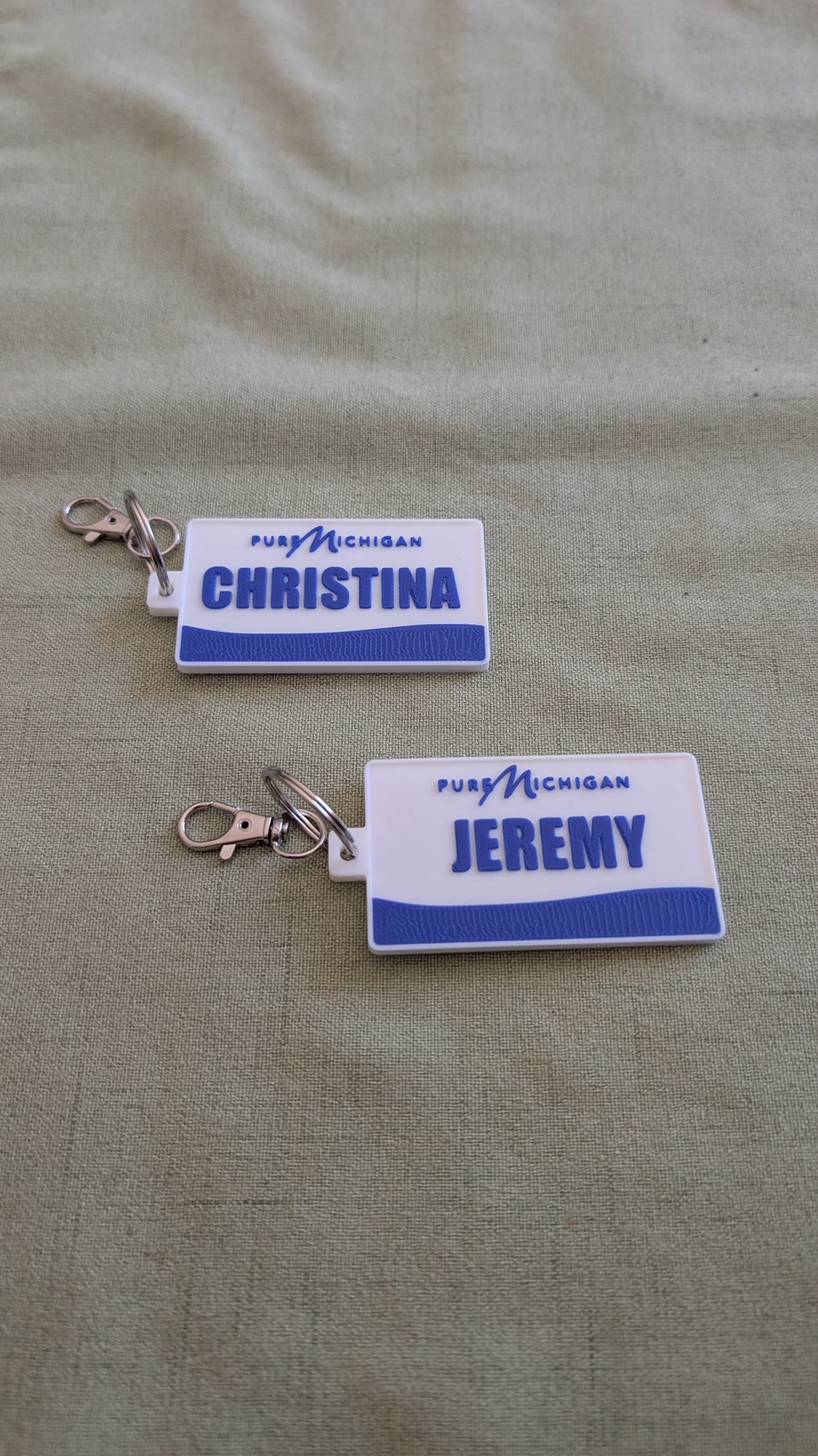 Two blue and white personalized Pure Michigan plate keychains