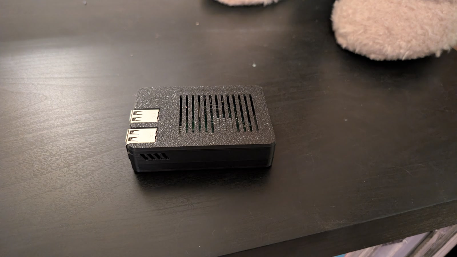 Black vented RoPieee Raspberry Pi case on a shelf