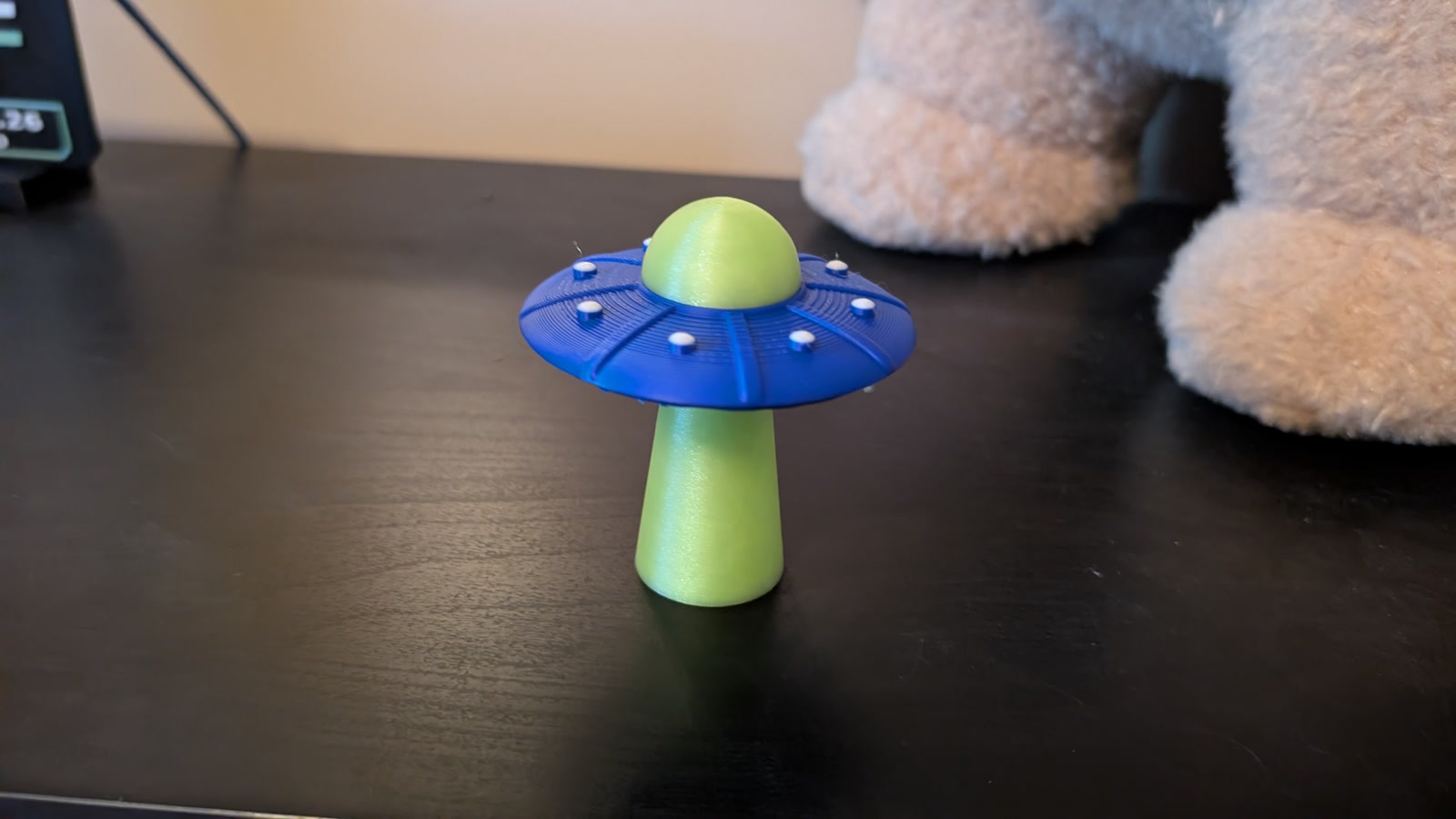Blue and lime flying saucer on a lime beam-shaped stand