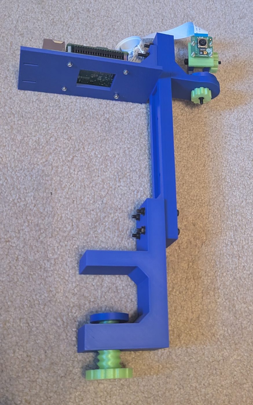 Assembled blue camera mount with green adjustment knobs lying on the work surface