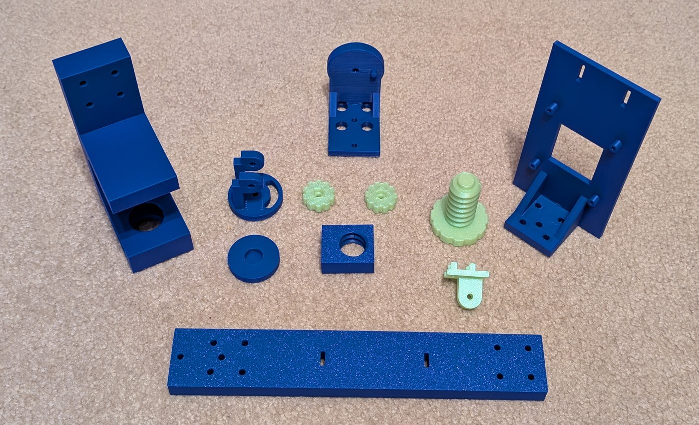 Blue clamp, upright, and camera-mount pieces laid out with green adjustment parts