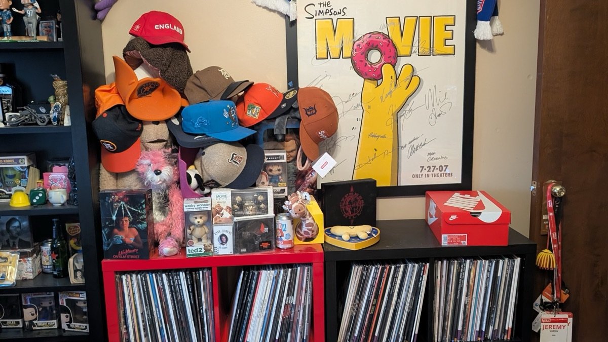 Record shelves covered with hats, collectibles, and boxes before clearing the printer space