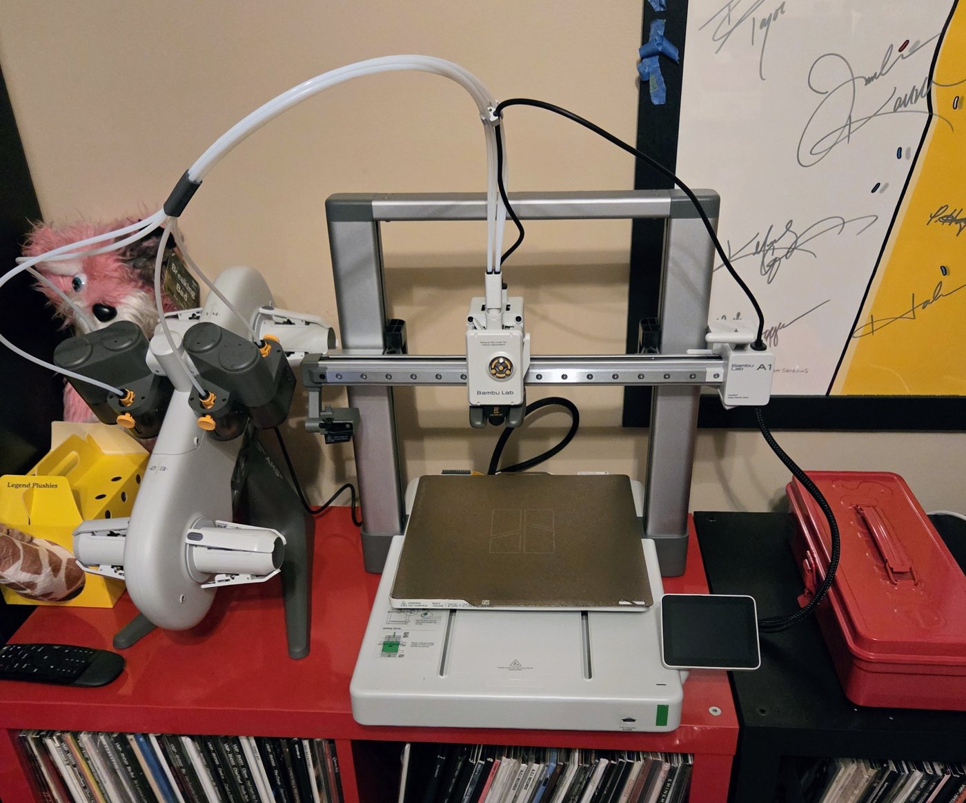 Assembled Bambu Lab A1 and AMS Lite on the red cabinet with filament tubes connected